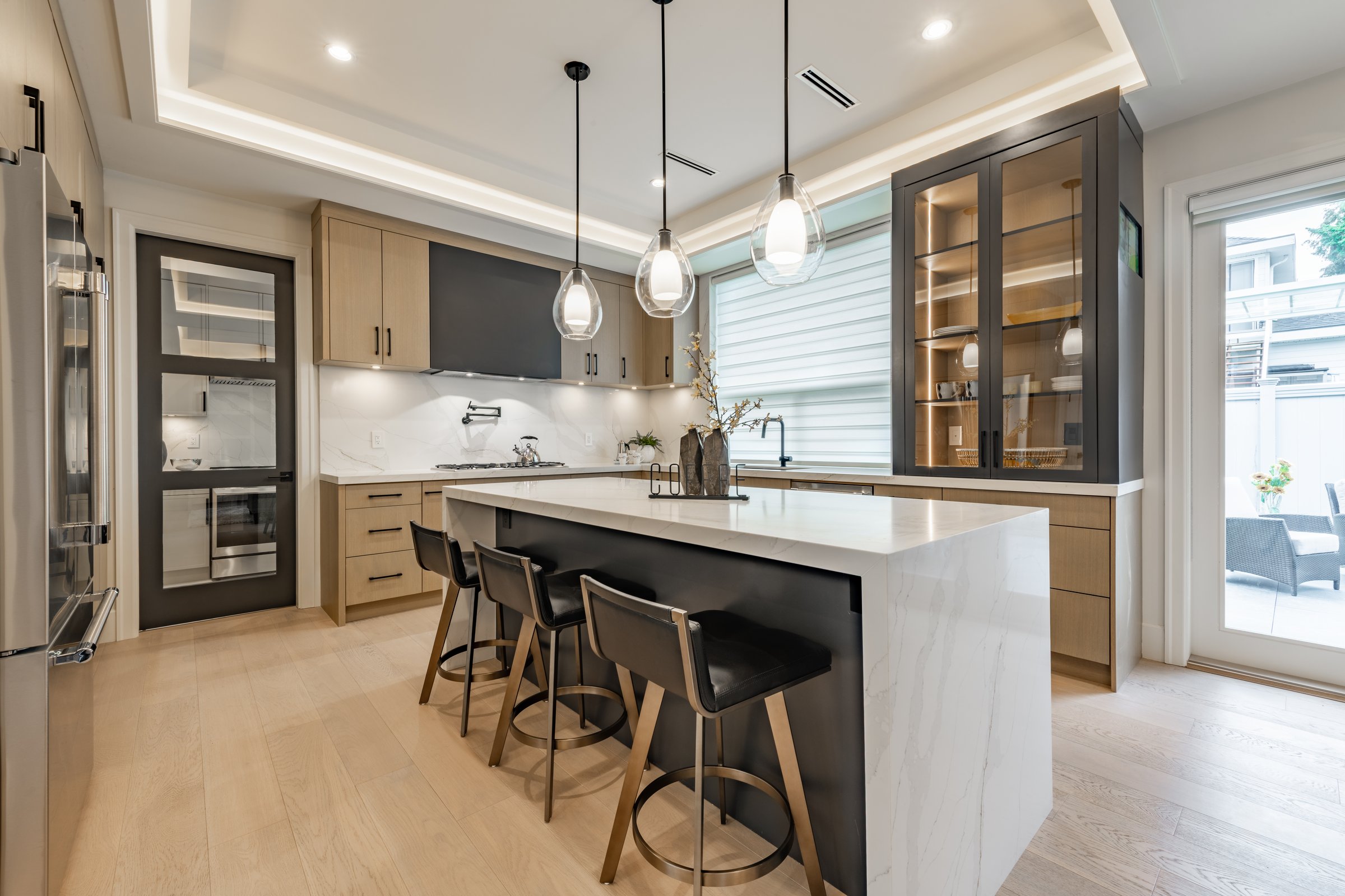 Kitchen with bar stools, white countertops, and wood cabinets