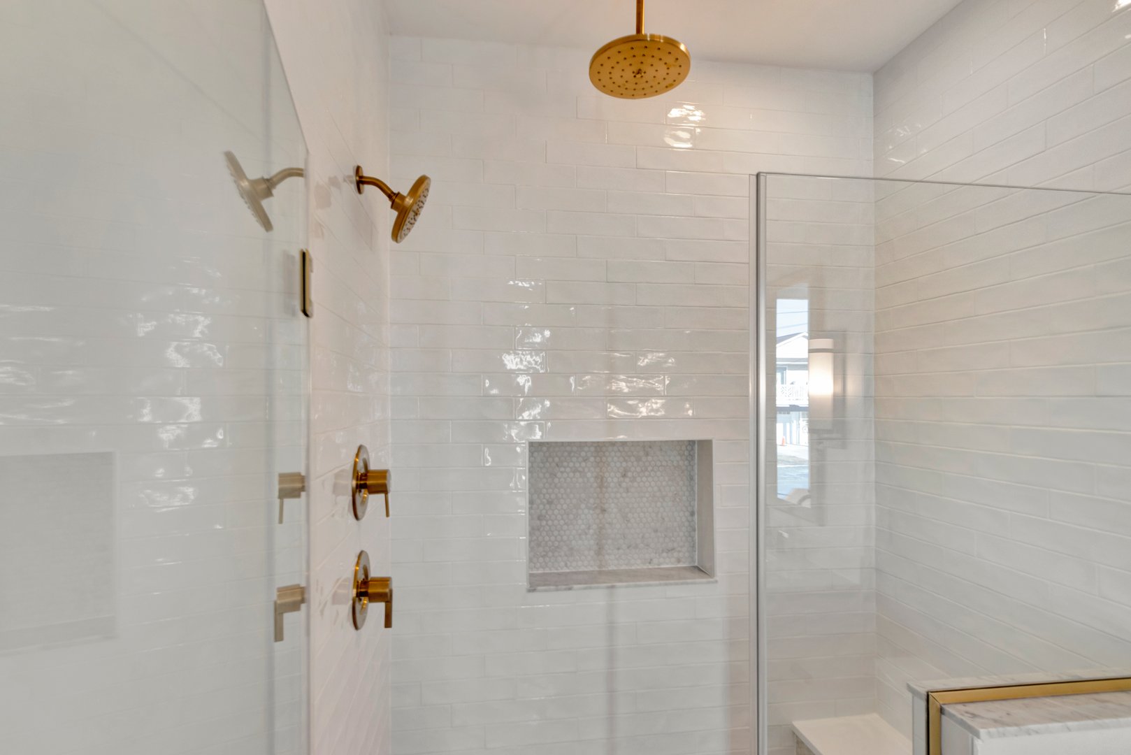 White tiled walk-in shower with glass door